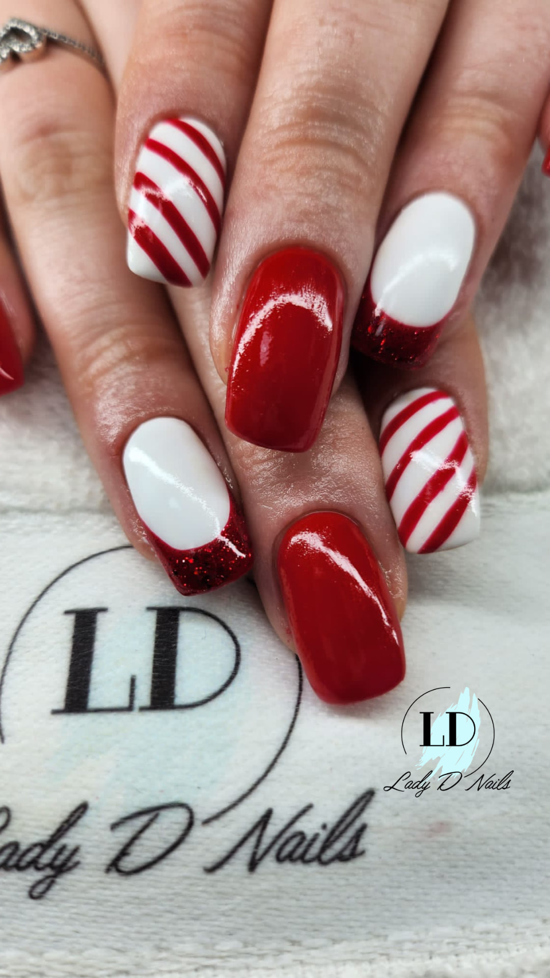 Rote und weisse Nägel mit Candy-Cane-Streifen und rotem Glitzer