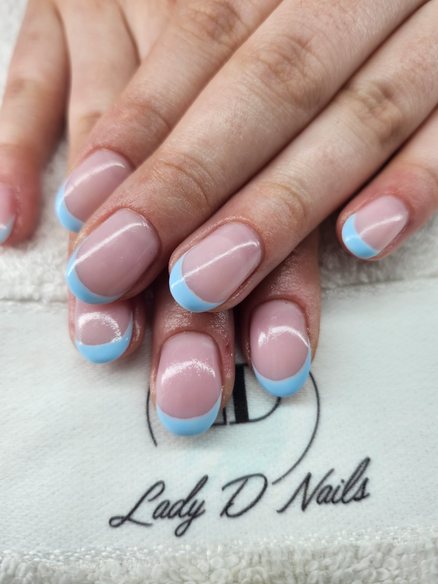 Ovale Nägel mit babyblauer French-Spitze auf rosé Nagelbett